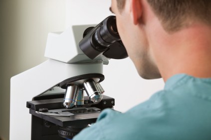 A doctor looking into a microscope