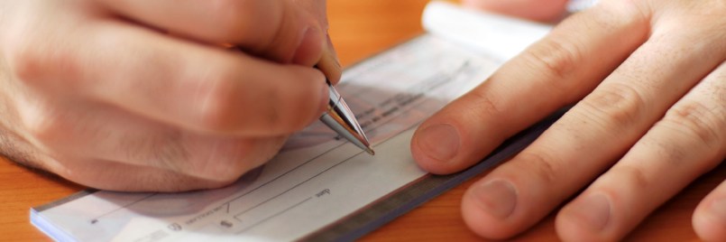 A person writing a check for payment